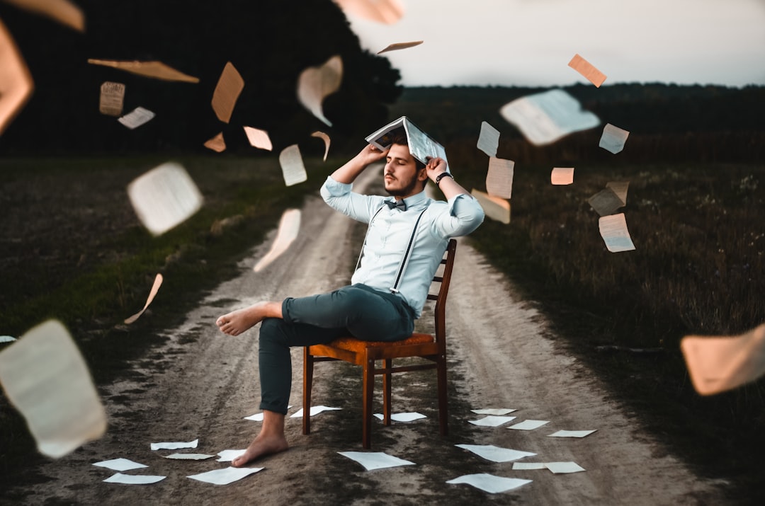 Photo by Dmitry Ratushny man sitting on chair with book